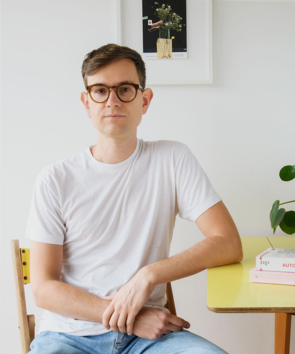 A man wearing a white t shirt standing against a white background